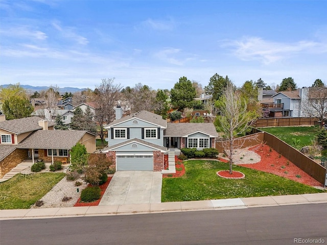 traditional-style home featuring a residential view, fence, driveway, and a front yard