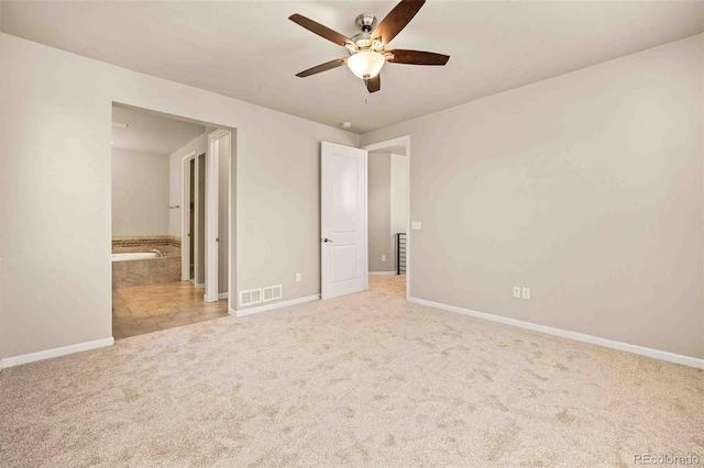 unfurnished bedroom featuring ensuite bathroom, carpet floors, and baseboards