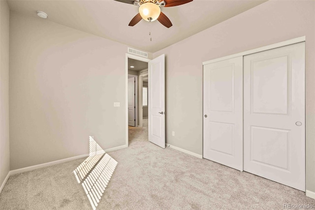 unfurnished bedroom featuring baseboards, visible vents, ceiling fan, carpet floors, and a closet