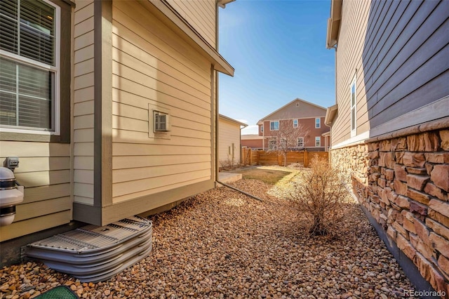 view of side of home featuring fence