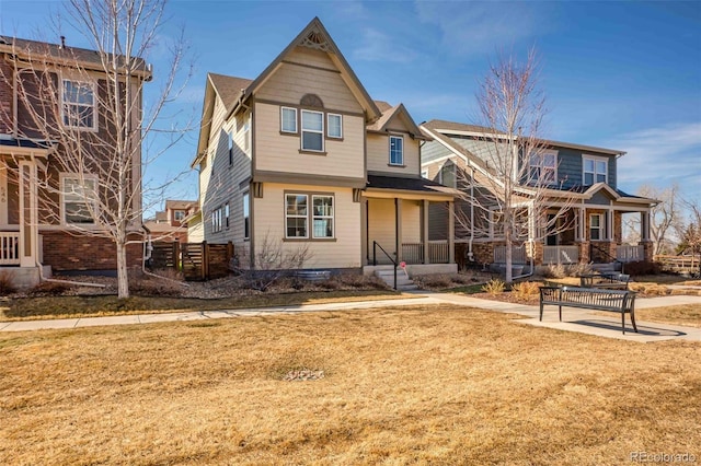 view of front of property with covered porch, a front lawn, and fence