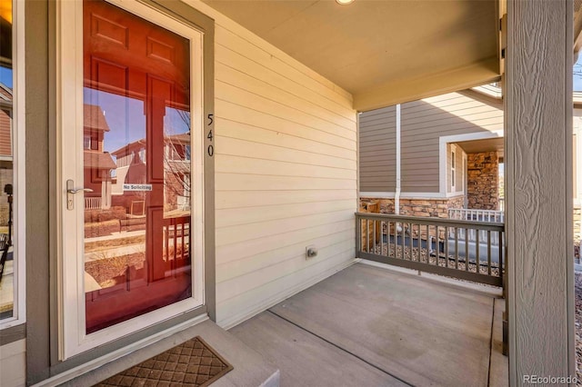 doorway to property featuring a porch and stone siding