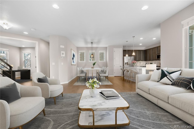 living room with wood finished floors, baseboards, and recessed lighting