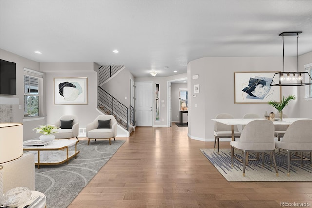 living room with baseboards, wood finished floors, stairs, and recessed lighting