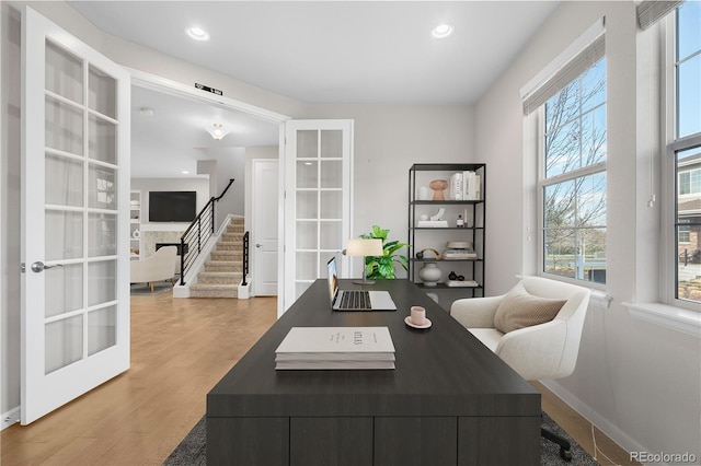 home office featuring baseboards, french doors, wood finished floors, and recessed lighting