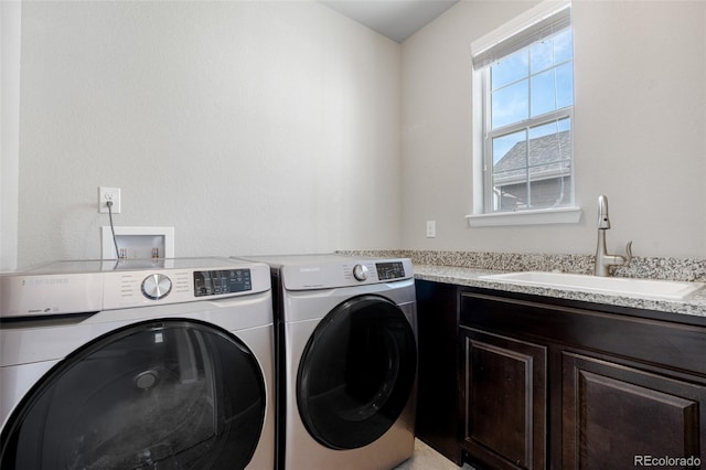 laundry area featuring a sink, washing machine and clothes dryer, and cabinet space