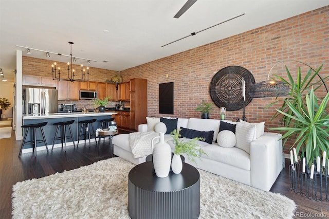 7240 W Custer Ave Unit 303, Lakewood, CO 80226 - living room with dark wood finished floors, a chandelier, brick wall, and rail lighting