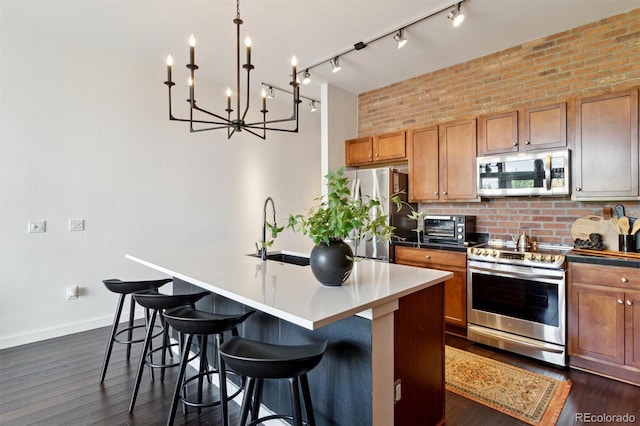 7240 W Custer Ave Unit 303, Lakewood, CO 80226 - kitchen with stainless steel appliances, a chandelier, tasteful backsplash, a breakfast bar, and brown cabinetry