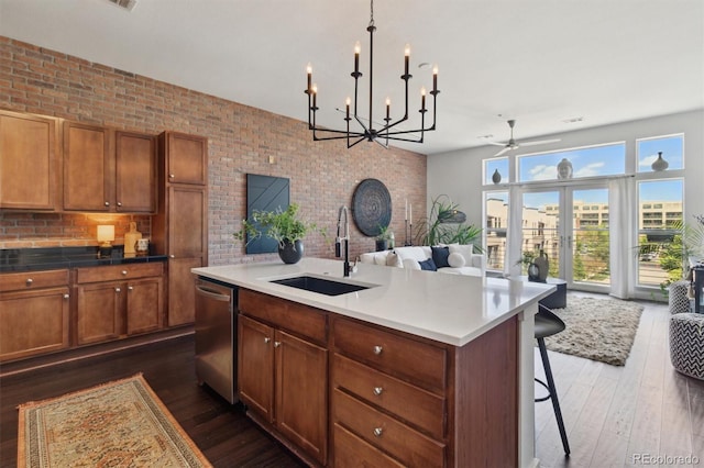 7240 W Custer Ave Unit 303, Lakewood, CO 80226 - kitchen featuring a sink, dishwasher, open floor plan, dark wood-style floors, and brown cabinets