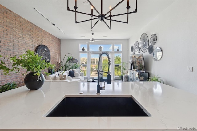 7240 W Custer Ave Unit 303, Lakewood, CO 80226 - detailed view of a sink, light stone countertops, a chandelier, brick wall, and a fireplace