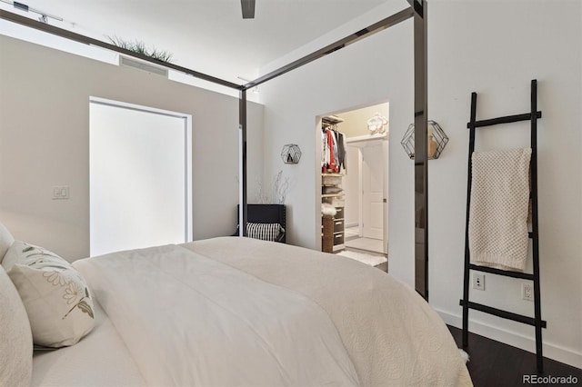 7240 W Custer Ave Unit 303, Lakewood, CO 80226 - bedroom featuring a spacious closet, wood finished floors, a closet, ceiling fan, and baseboards