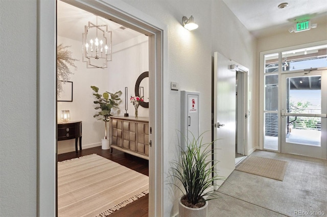 7240 W Custer Ave Unit 303, Lakewood, CO 80226 - hall featuring a chandelier, baseboards, wood finished floors, and a textured wall