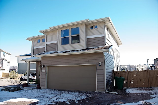 view of front facade with an attached garage and fence