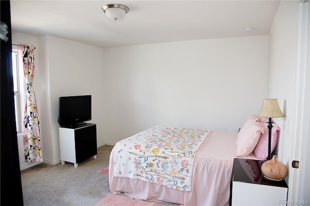 bedroom featuring light colored carpet and baseboards