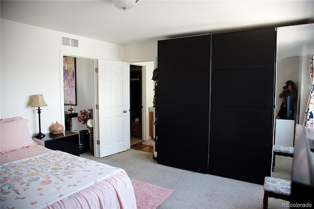 bedroom featuring visible vents and light carpet