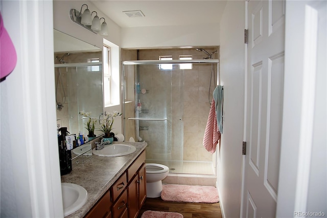 bathroom featuring a shower stall, visible vents, a sink, and double vanity