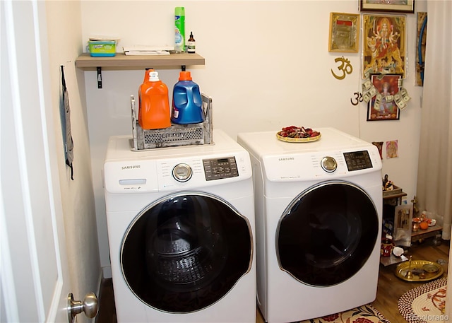 laundry room featuring laundry area, washing machine and dryer, and wood finished floors