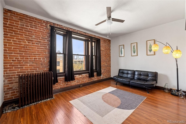 1475 N Humboldt St Unit 20, Denver, CO 80218 - living room featuring radiator, wood finished floors, ornamental molding, a ceiling fan, and baseboards