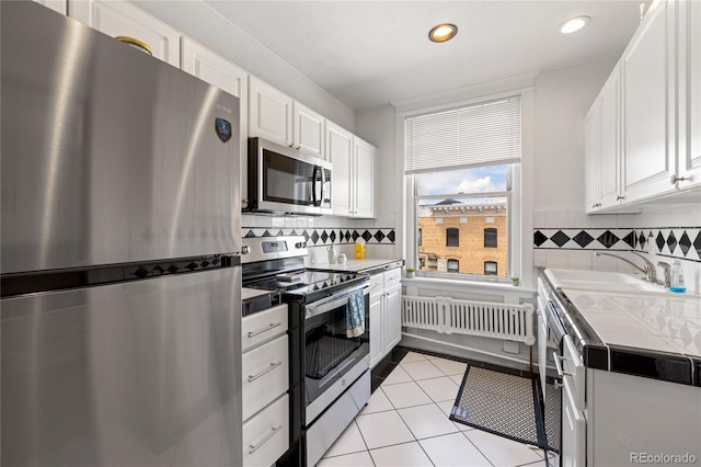 1475 N Humboldt St Unit 20, Denver, CO 80218 - kitchen with white cabinets, appliances with stainless steel finishes, tasteful backsplash, and recessed lighting