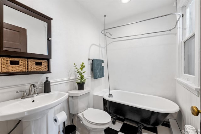 1475 N Humboldt St Unit 20, Denver, CO 80218 - full bathroom featuring a wainscoted wall, toilet, a sink, and a combined bath / shower with freestanding tub