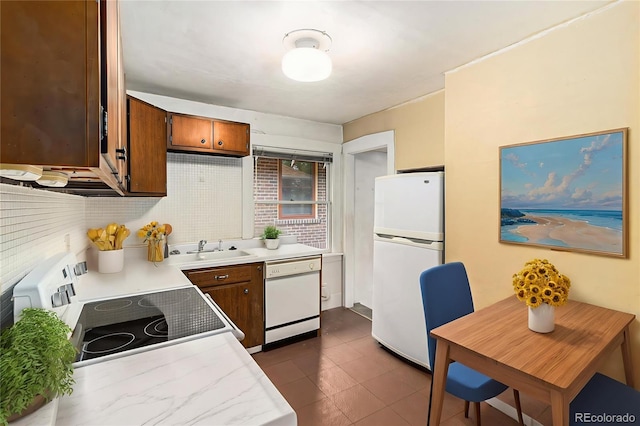 4010 Grove St, Denver, CO 80211 - kitchen with white appliances, light countertops, backsplash, brown cabinets, and dark tile patterned floors