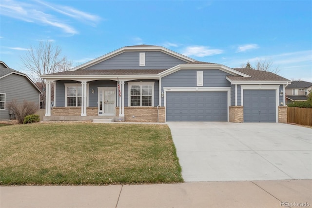 view of front of home with an attached garage, concrete driveway, a front yard, and brick siding