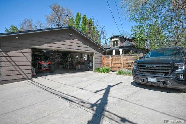1027 S University Blvd, Denver, CO 80209 - view of vehicle parking with concrete driveway, a garage, and fence