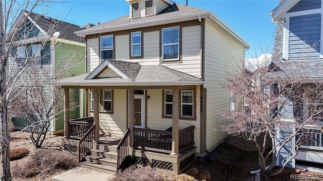 traditional style home featuring a porch and a shingled roof