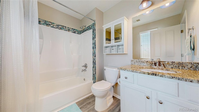 bathroom featuring vanity, wood finished floors, visible vents, shower / bath combo, and toilet