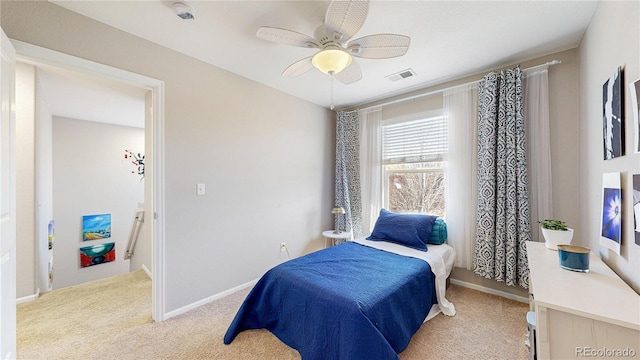 bedroom featuring visible vents, baseboards, light colored carpet, and a ceiling fan