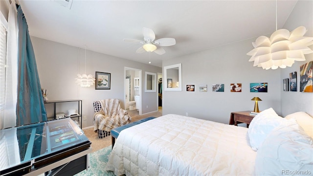 carpeted bedroom featuring baseboards, ensuite bath, and ceiling fan