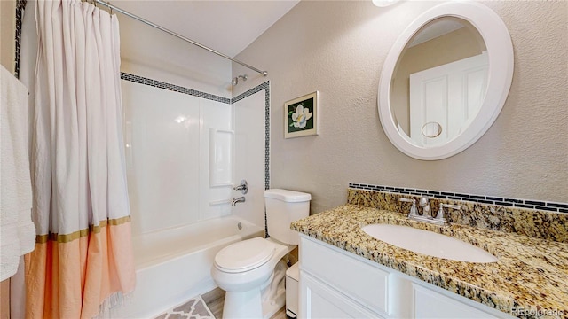 full bath featuring vanity, shower / bathtub combination with curtain, toilet, and a textured wall