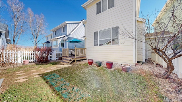 back of house with a yard, a deck, and fence