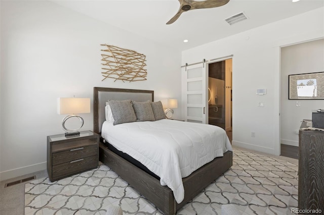 bedroom with ceiling fan, a barn door, and light carpet