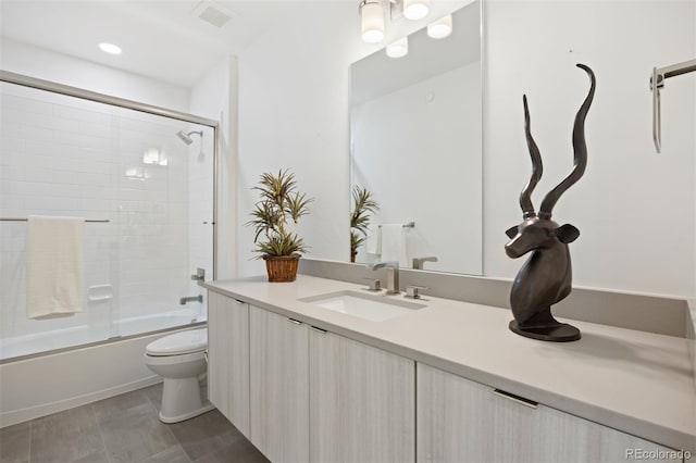 full bathroom with toilet, vanity, and shower / bath combination with glass door