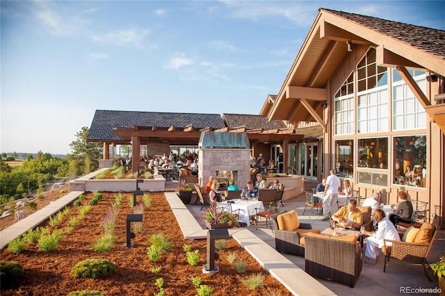 exterior space with a patio area and an outdoor living space with a fireplace