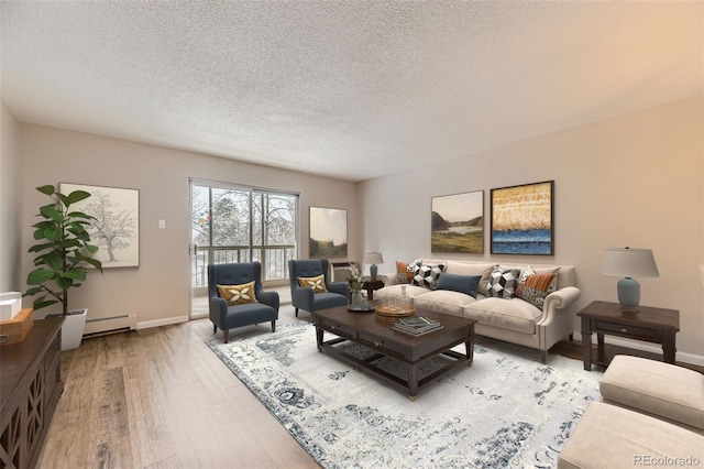 living room with a baseboard radiator, light hardwood / wood-style floors, and a textured ceiling