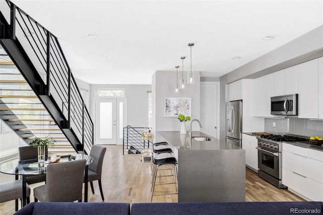 3156 W 20th Ave, Denver, CO 80211 - kitchen with appliances with stainless steel finishes, modern cabinets, dark countertops, decorative backsplash, and a kitchen bar