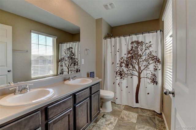 5837 High Timber Cir, Castle Rock, CO 80104 - bathroom with visible vents, a sink, double vanity, and stone finish flooring