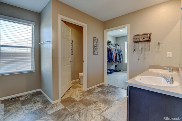 5837 High Timber Cir, Castle Rock, CO 80104 - bathroom featuring visible vents, toilet, a sink, stone finish flooring, and baseboards