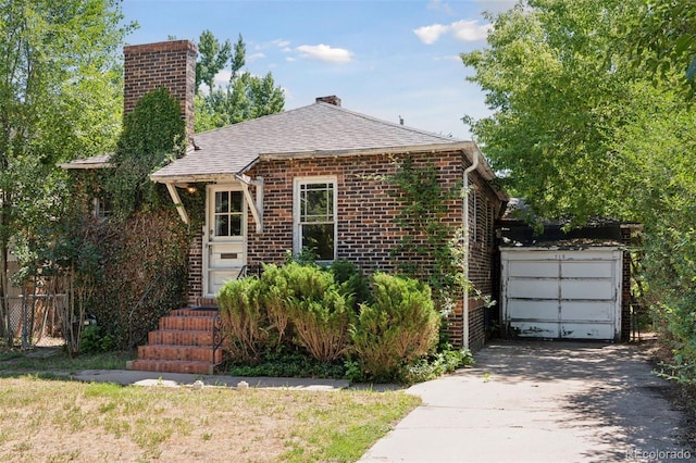 712 Locust St, Denver, CO 80220 - view of front of home with asphalt driveway, brick siding, a chimney, and roof with shingles