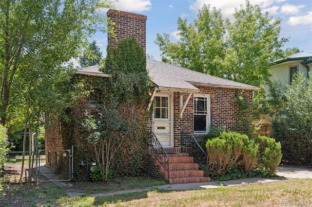 712 Locust St, Denver, CO 80220 - view of front of house featuring a chimney, a gate, roof with shingles, and brick siding