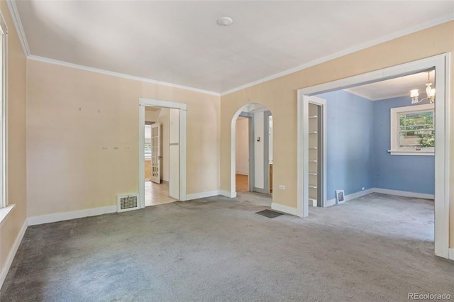 712 Locust St, Denver, CO 80220 - carpeted empty room featuring arched walkways, crown molding, and a chandelier