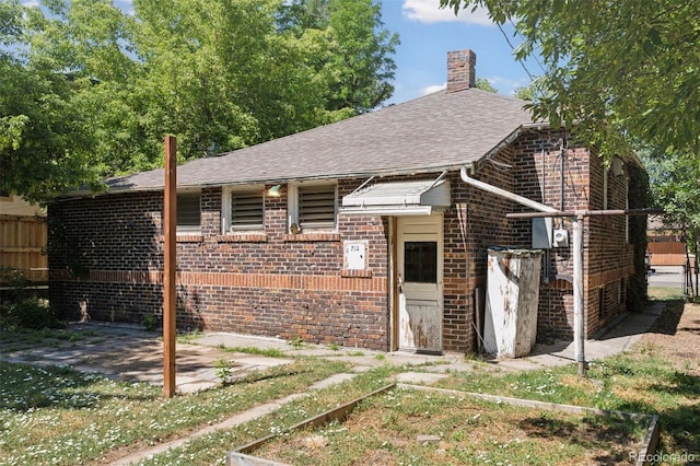 712 Locust St, Denver, CO 80220 - view of front of home with brick siding, a chimney, roof with shingles, and a patio