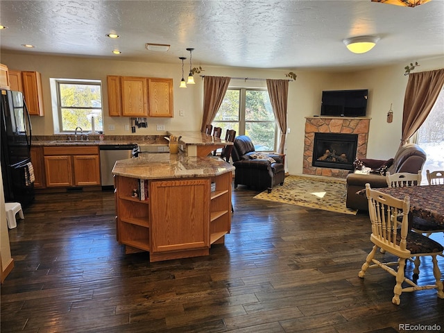 kitchen featuring freestanding refrigerator, a peninsula, stainless steel dishwasher, open shelves, and a sink