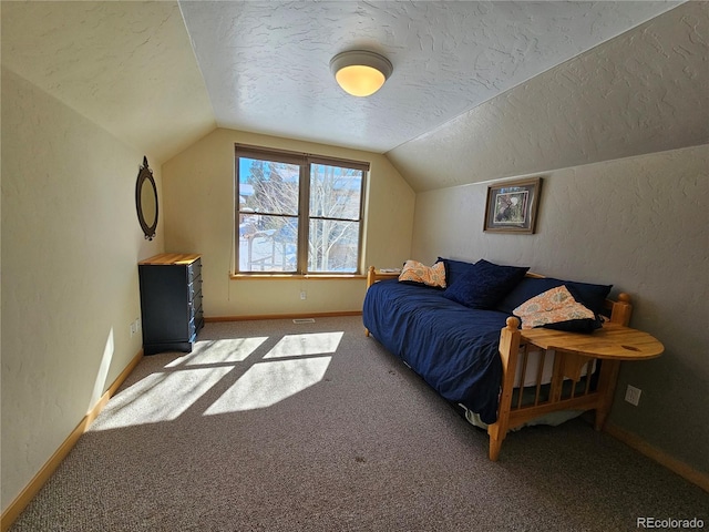 bedroom with lofted ceiling, a textured ceiling, and a textured wall