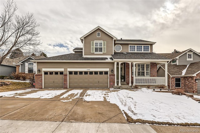 traditional-style house with a garage, concrete driveway, brick siding, and a porch