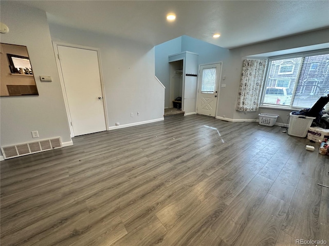 unfurnished living room featuring wood finished floors, visible vents, and baseboards