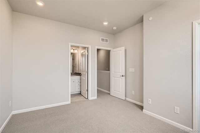 unfurnished bedroom with light carpet and ensuite bath