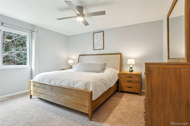 bedroom featuring light carpet, baseboards, and a ceiling fan